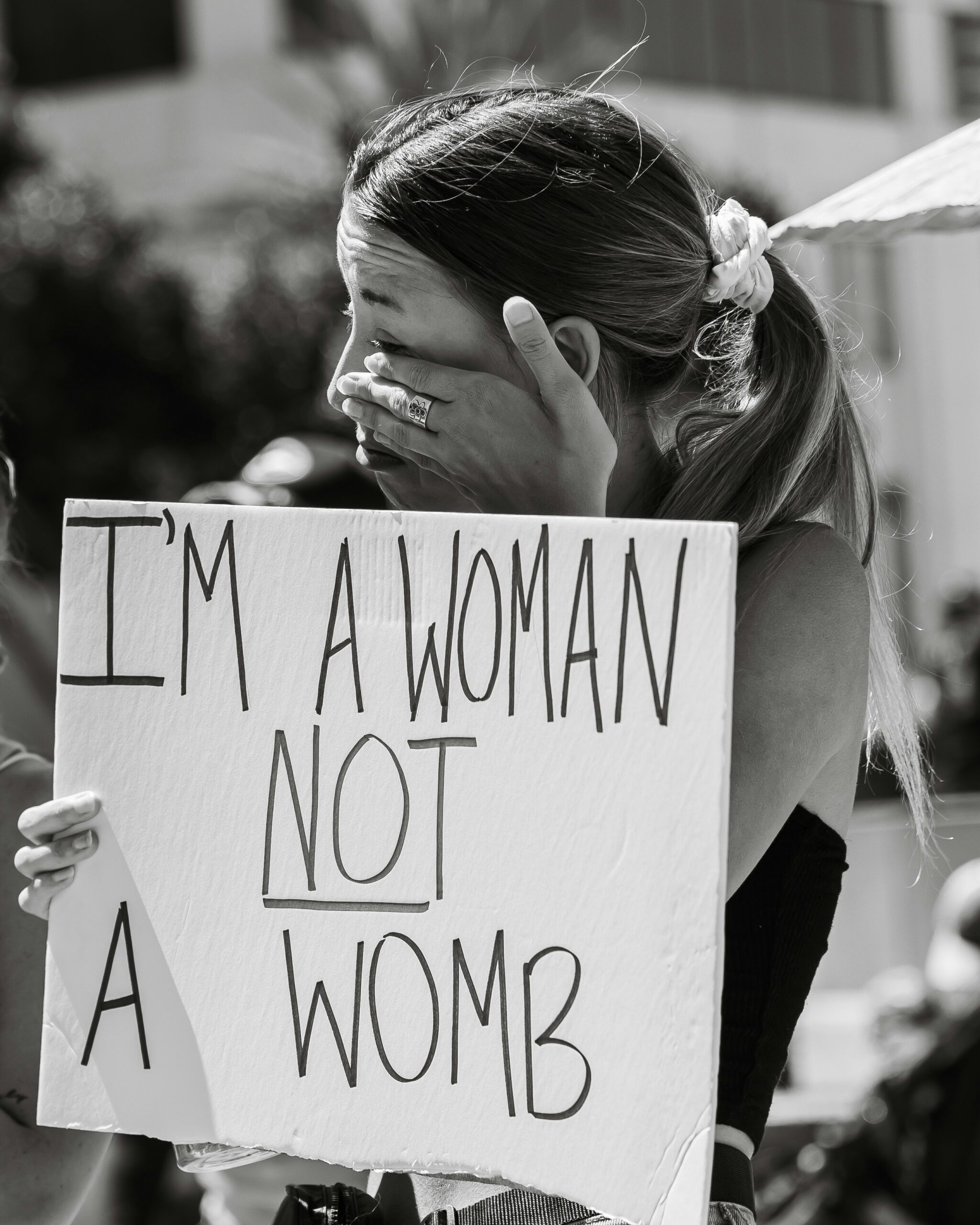 immagine BN una donna manifesta contro utero in affitto. cartello con scritto I'm a woman not a womb